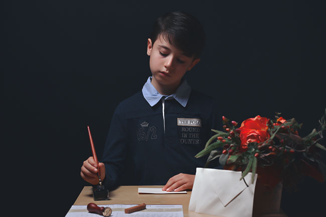 Foto di bambino che scrive su un tavolino scattata da Ferruccio Munzittu