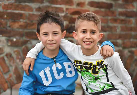 Foto di due bambini abbracciati che ridono, foto scattata all'aperto da Ferruccio Munzittu
