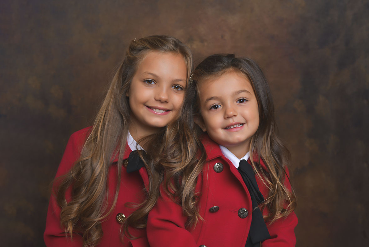 foto in studio di Ferruccio Munzittu ritraente due sorelline con il cappotto rosso