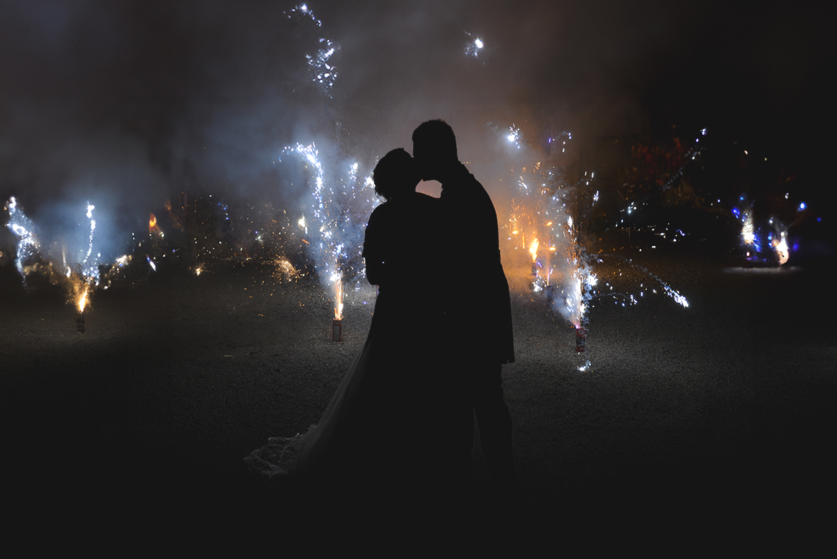 Immagine dei due novelli sposi che ci baciano in mezzo ai fuochi d'artificio, foto di Ferruccio Munzittu