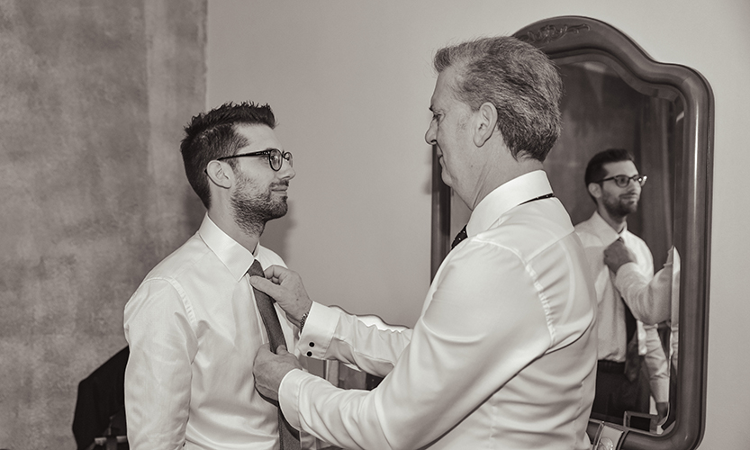 Immagine del papà che sistema la cravata al futuro sposo, foto di Ferruccio Munzittu